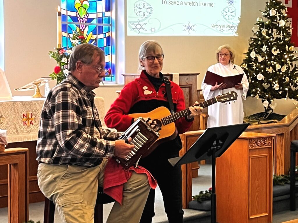 A picture of two musicians performing for the church